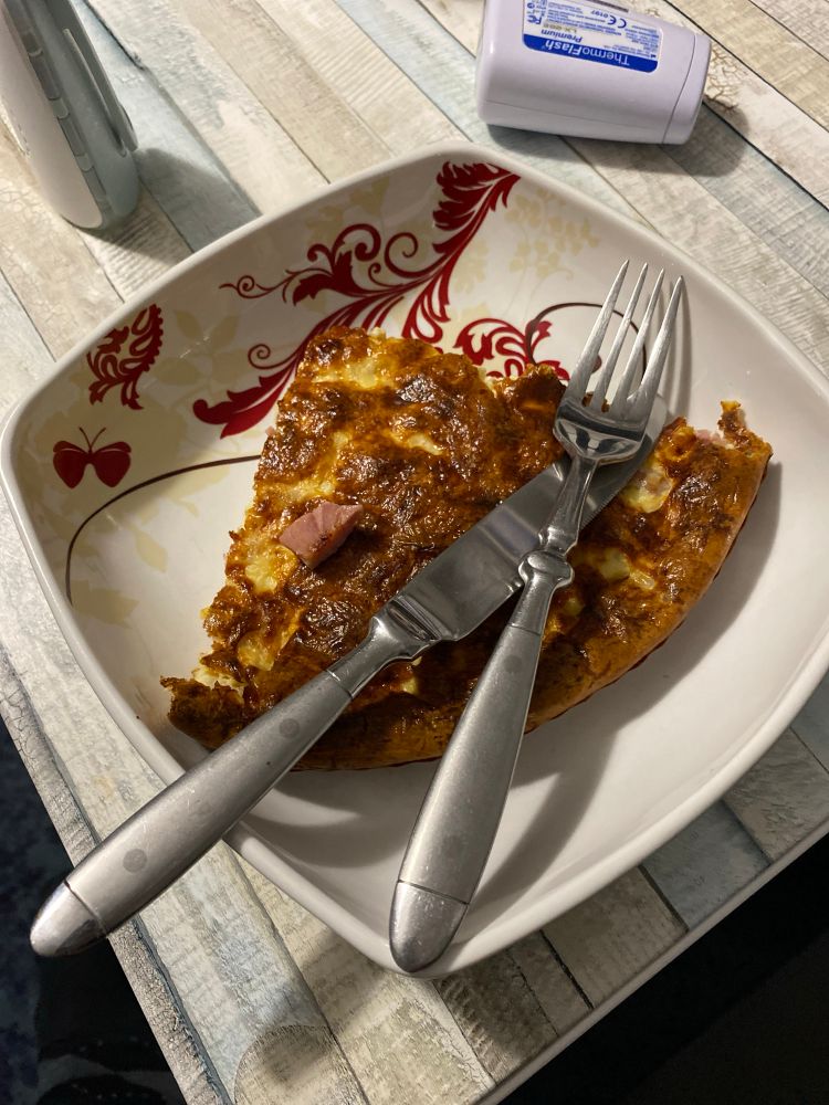 Une assiette contenant une part de quiche sans pâte et des couverts.