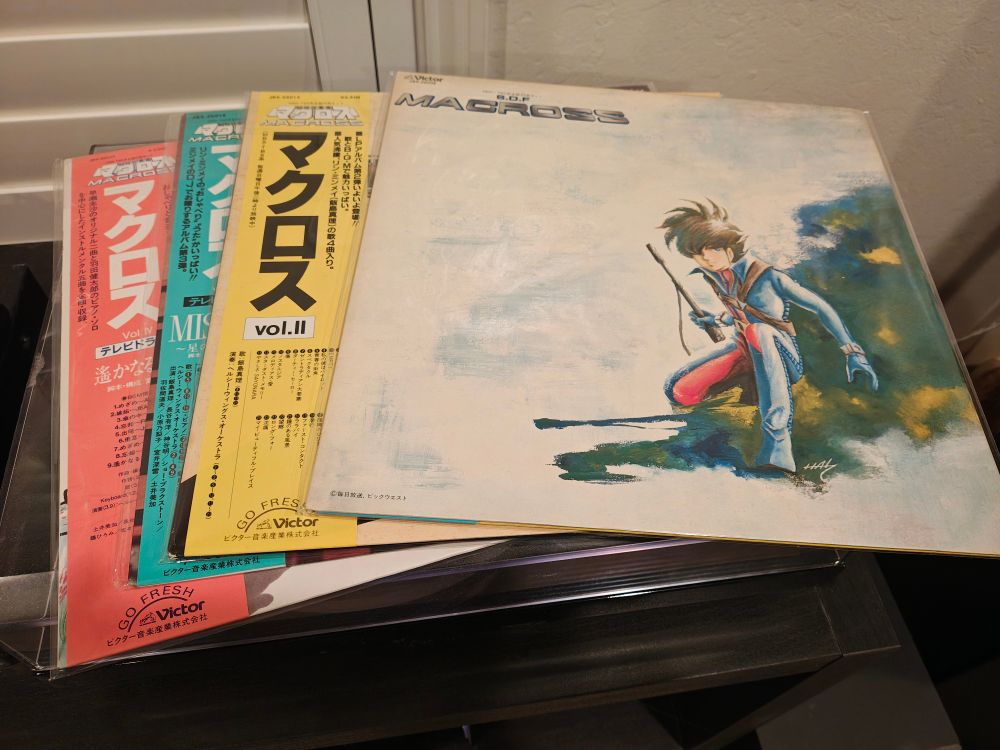 The four SDF Macross soundtrack album records lie on top of a record player.