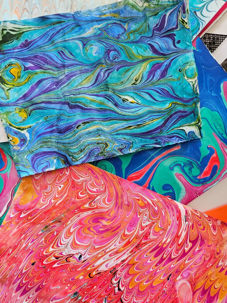 Random colorful pieces of paper with marbled patterns of blues and pinks 