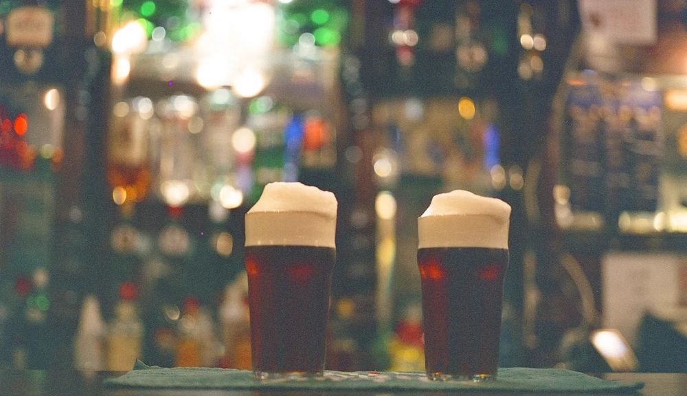 Banked pints standing on a bar counter in Teesside with a shimmering backbar in soft focus behind. Photo by Reece Hugill.