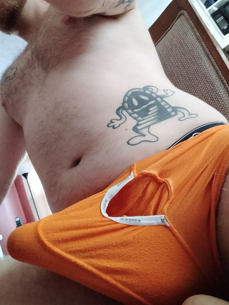 Hard cock in orange boxers sitting at a dining chair