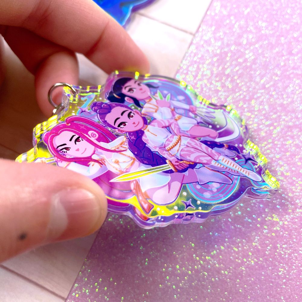 Another angle of the keychain showing off the acrylic, which is iridescent and shifts color depending on the lighting and angle.