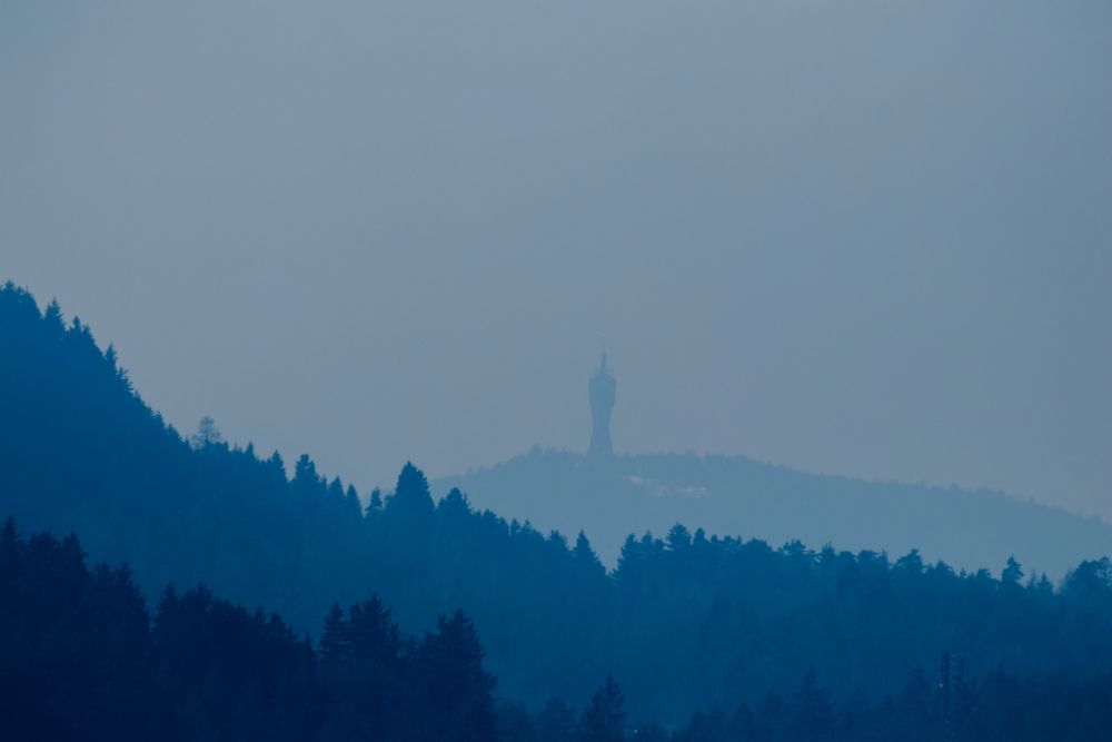 Picture shows a misty landscape with a tower in the background. 