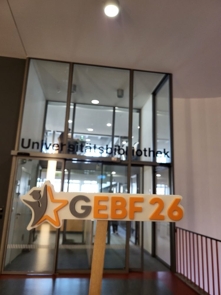 Eingang der Universitätsbibliothek der TU München und Logo des GEBF26-Kongresses