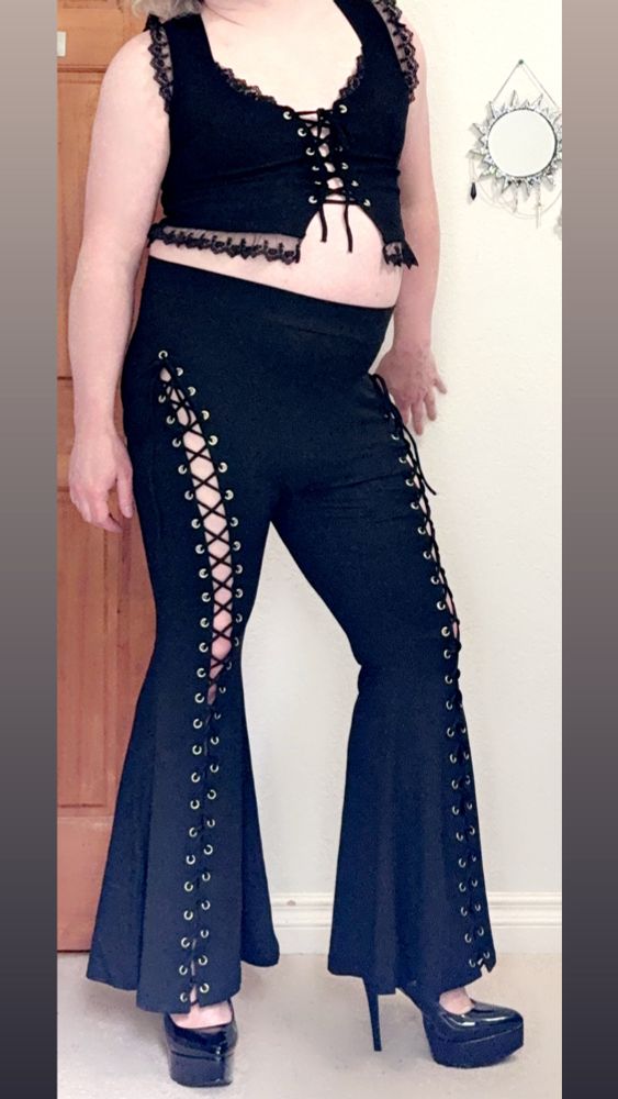 Posing in an all black outfit from Forest Ink. Lace up flatted leggings and a lace up top paired with shiny black high heels.