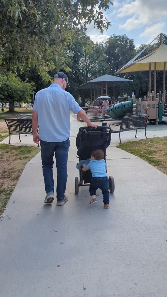 My son and I, dressed in blue shirts with jeans, pushing a stroller together.  It's cute as hell.