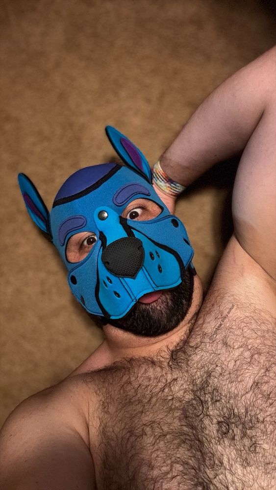 Me in my blue pup hood. Laying down shirtless with arm behind head