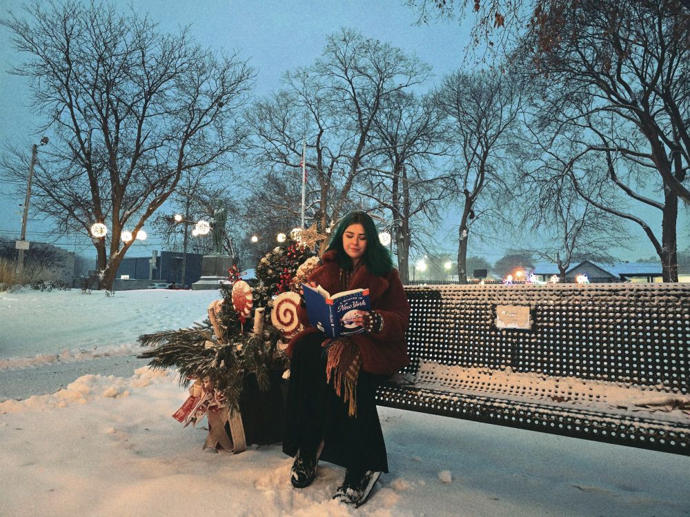 Reading on a bench in the snow 