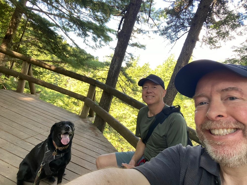 Taking a breather. Two guys and one black lab.