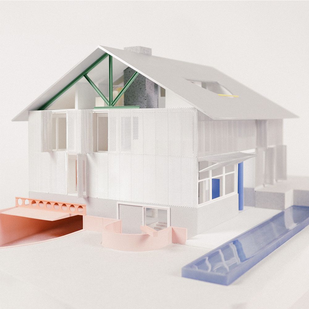 A 1:50 scale model of a house, shaped like a house, made with resin, wood, aluminum, metal mesh and acrylic. Elements of the house, such as the structure and elevator core, are expressed in color.