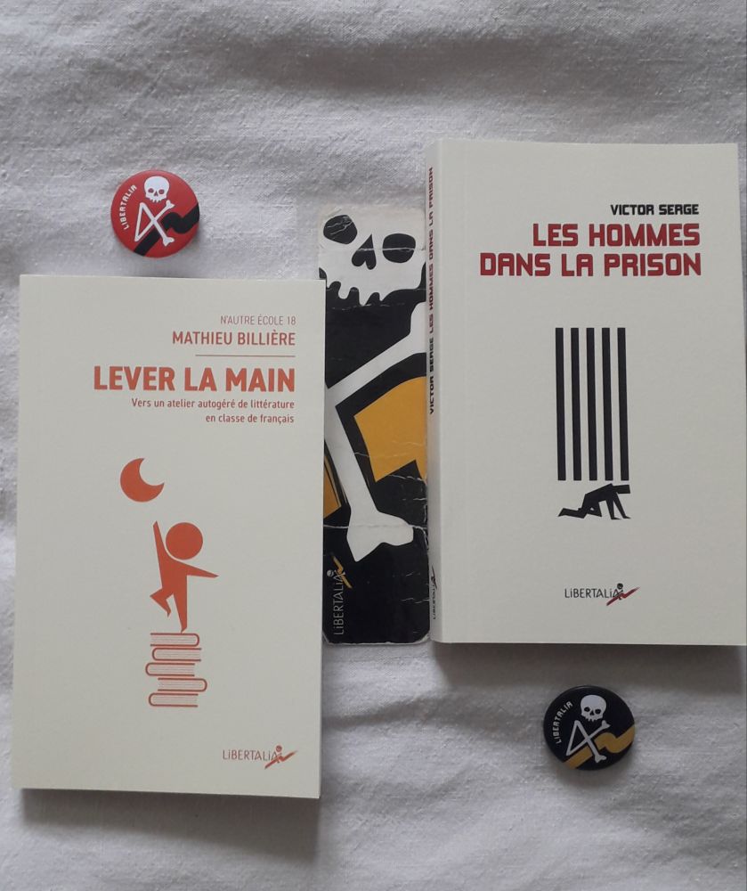 Couvertures de deux livres aux Éditions Libertalia :
" Les hommes dans la prison " par Victor Serge. 
On y voit un dessin stylisé à l'encre noir, un homme est terrassé, à quatre pattes, par cinq barreaux de prison. 
" Lever la main " - Vers un atelier autogéré de littérature en classe de français par Mathieu Billière. 
On y voit un dessin stylisé en orange, un enfant est en équilibre sur cinq livres tentant de décrocher la lune. 
Les couvertures sont réalisées par Bruno Bartkowiak. 
À côté des livres, on voit mon marque-page Libertalia tout décrépit et deux badges Libertalia 