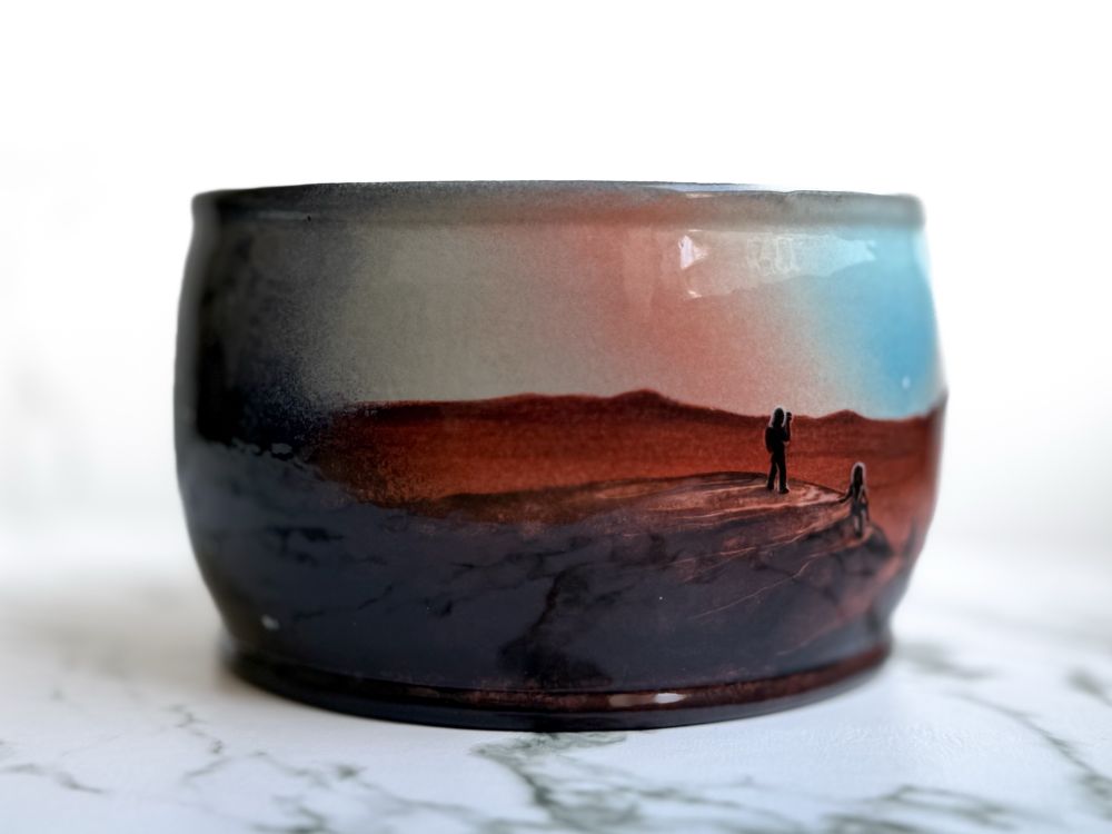 Yarn bowl featuring three hikers on a Martian landscape at sunset. (Left)