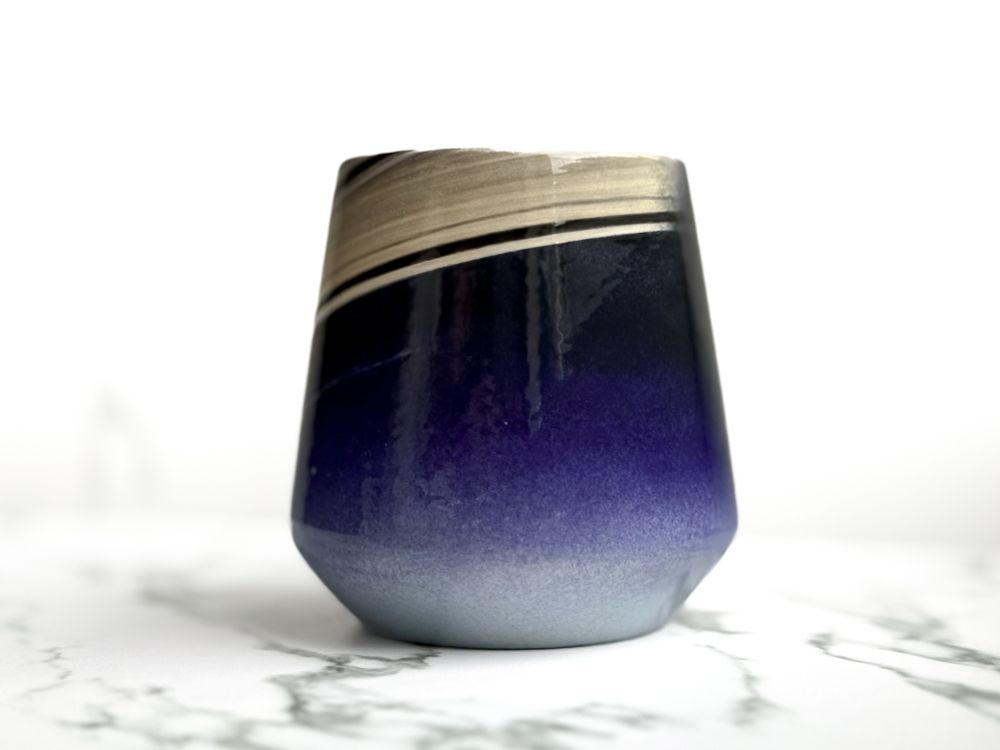 Angled cup featuring a hand painted design resembling the Cassini capture of Earth from Saturn as the "pale blue dot" (side)