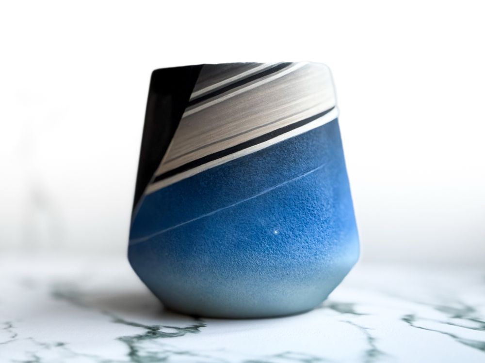 Angled cup featuring a tiny dot representing Earth framed by Saturn inspired by Cassini image 