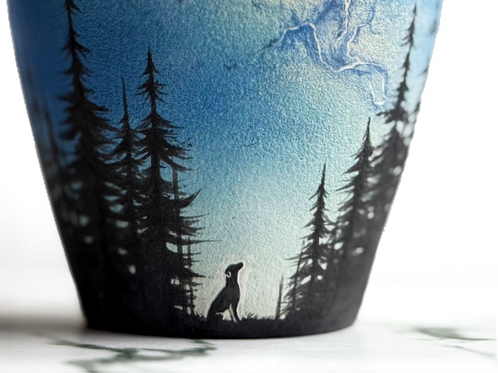 Urn with lid featuring silhouette of a dog looking up toward the Milky Way in the parting of a forest. Detail of dog.