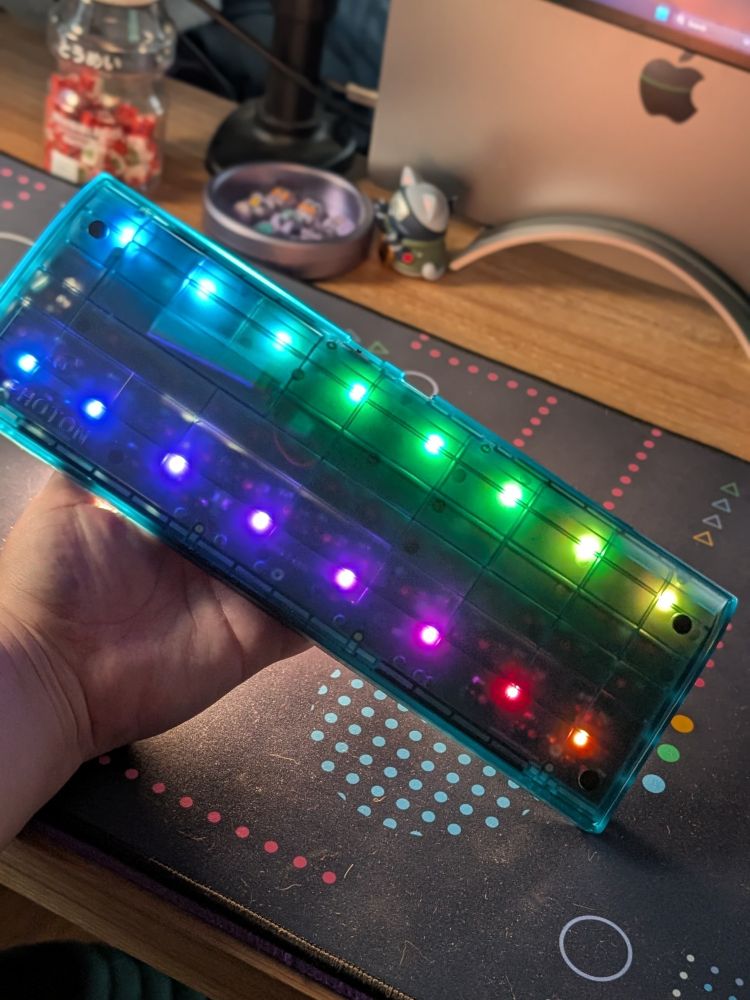 The back of a translucent blue Photon mechanical keyboard shows two rows of RGB LED lights shining through the case