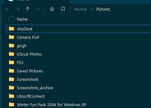 a screenshot of folders in the 'pictures' folder, showing 'anydesk', 'camera roll', 'gogh', 'icloud photos', 'ps3', 'saved pictures', 'screenshots', 'ubisoftconnect' and 'winter fun pack 2004 for windows xp'