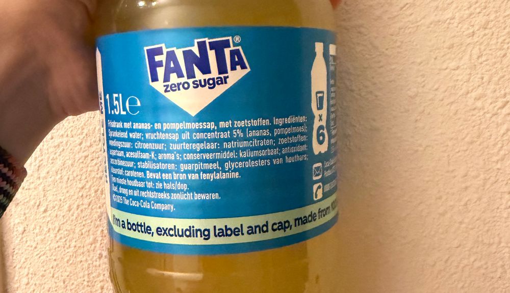a photo of a fanta bottle saying 'i'm a bottle, excluding label and cap, made from 100', with the remainder ('% recycled plastic') cut off
