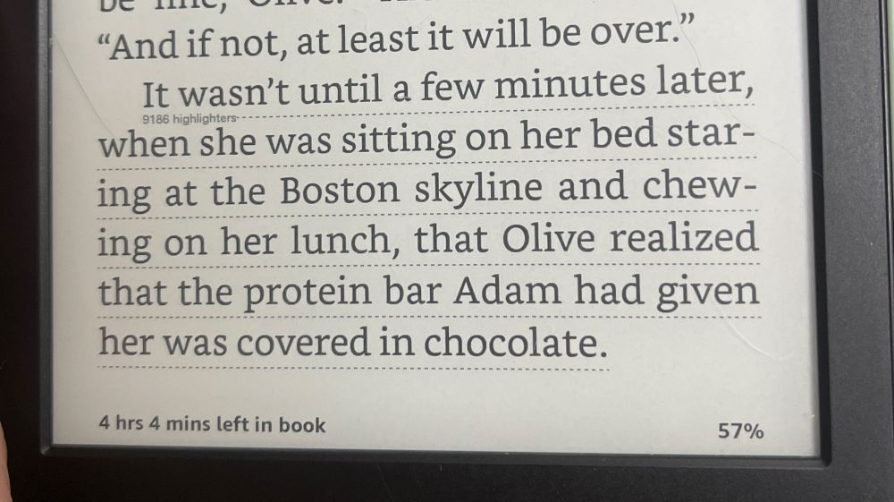 Kindle text that reads, “It wasn't until a few minutes later,
when she was sitting on her bed staring at the Boston skyline and chewing on her lunch, that Olive realized that the protein bar Adam had given her was covered in chocolate.”
