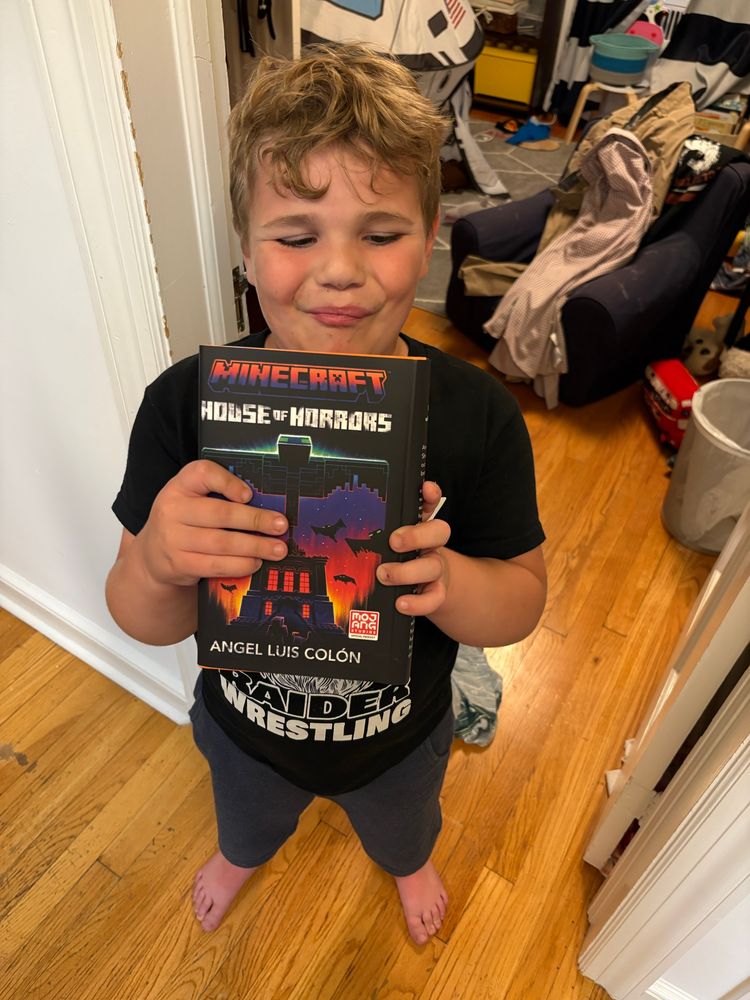 My kid holding Angel Luis Colon’s Minecraft book