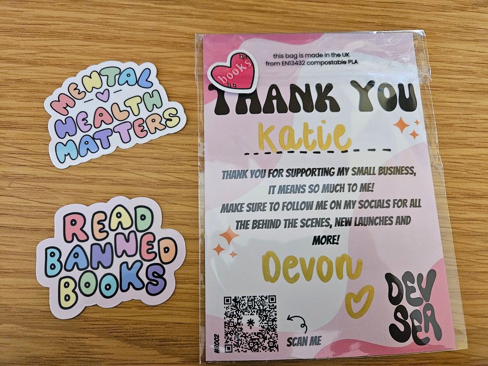 Two cute stickers of rainbow bubble writing. They read:

Read Banned Books

Mental Health Matters