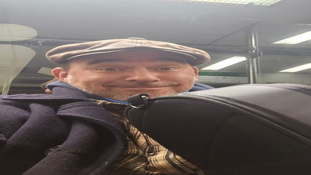 Debil grinsender Gitarrist auf dem Weg von der Probe in der S-Bahn