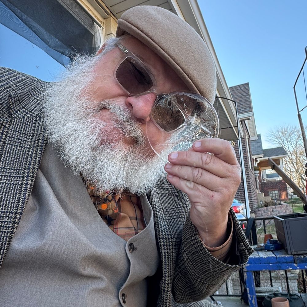 old guy in a brown suit holds a disk of ice