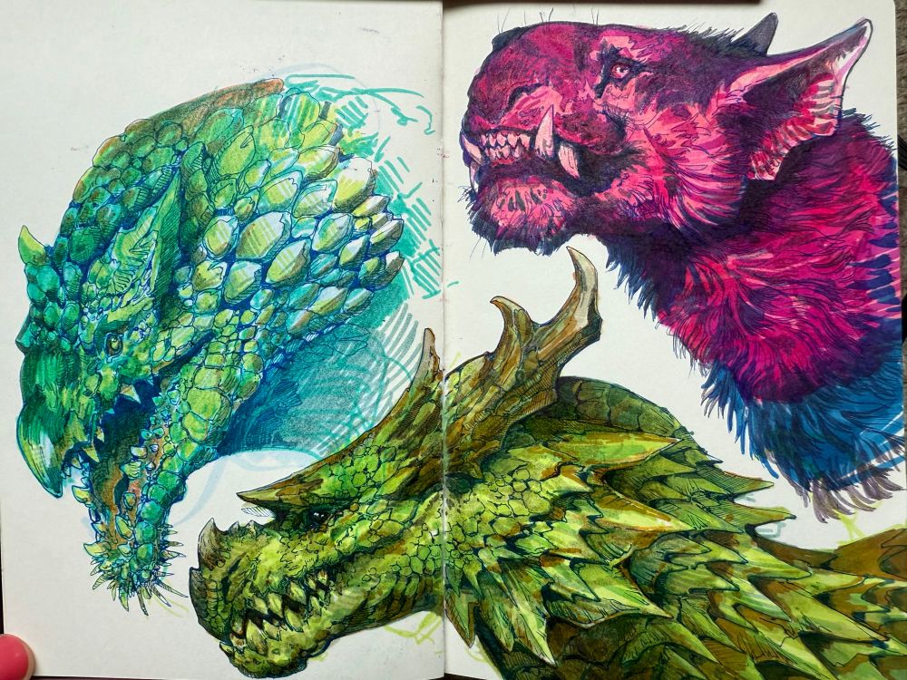 Sketchbook pages with three headshots: 2 dragons and a cat like creature. Lined in blue gel pen and colored with markers.