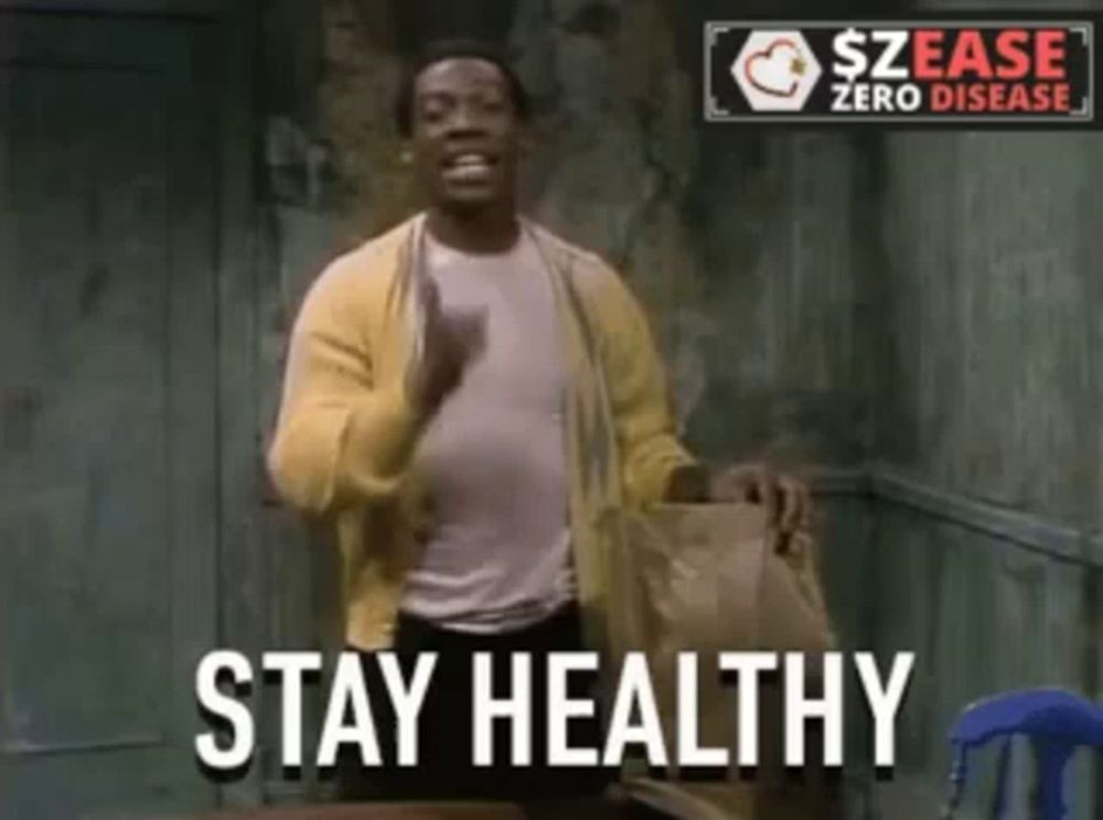 a man in a yellow cardigan stands in front of a sign that says " stay healthy "