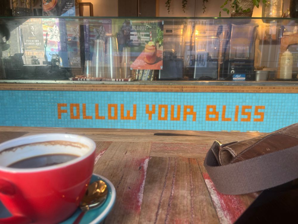 Sign in a cafe that says “Follow Your Bliss”