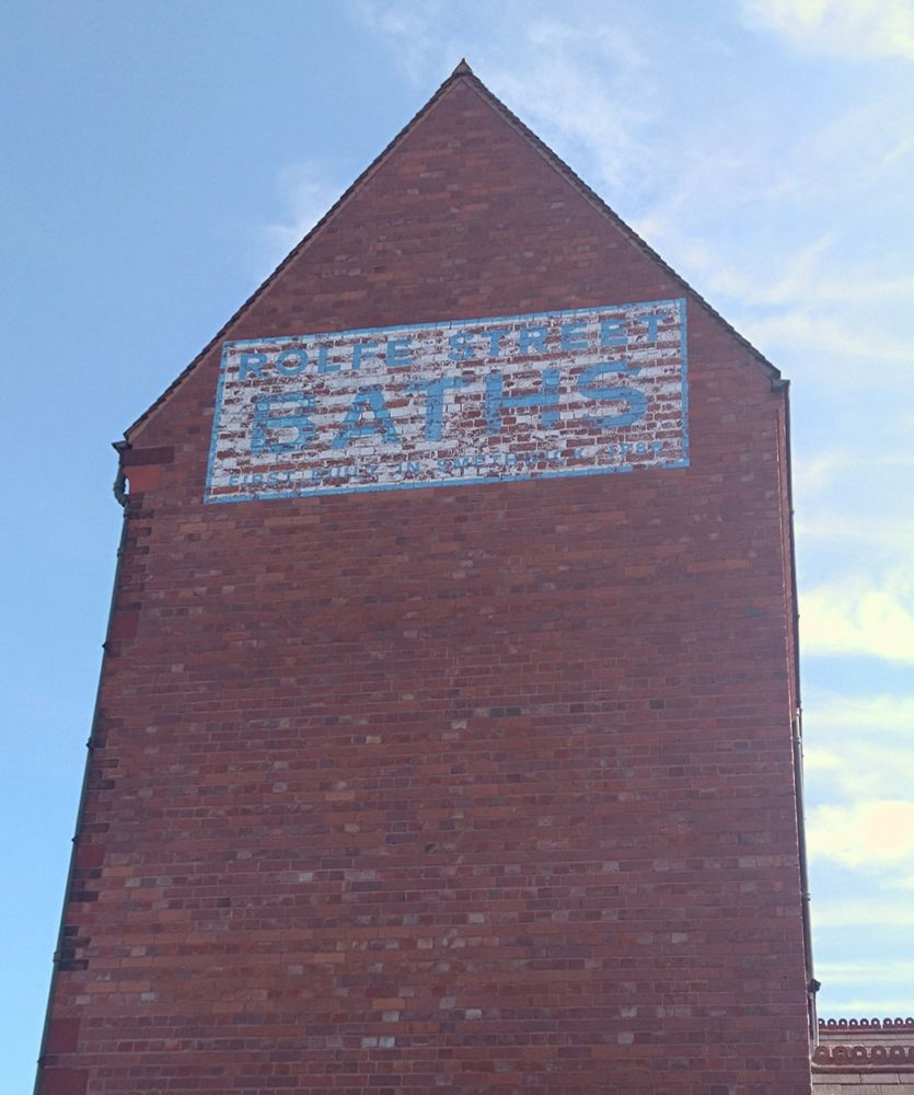 Tall building with Rolfe Street Baths sign. 
