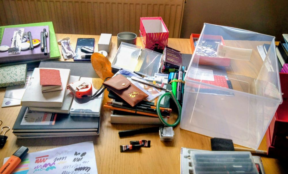 Picture of messy desk with lots of art materials.