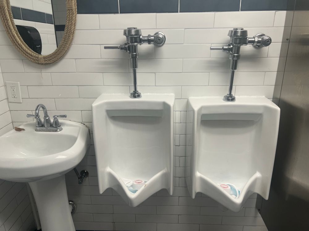 A sink and two urinals, all less than six inches apart