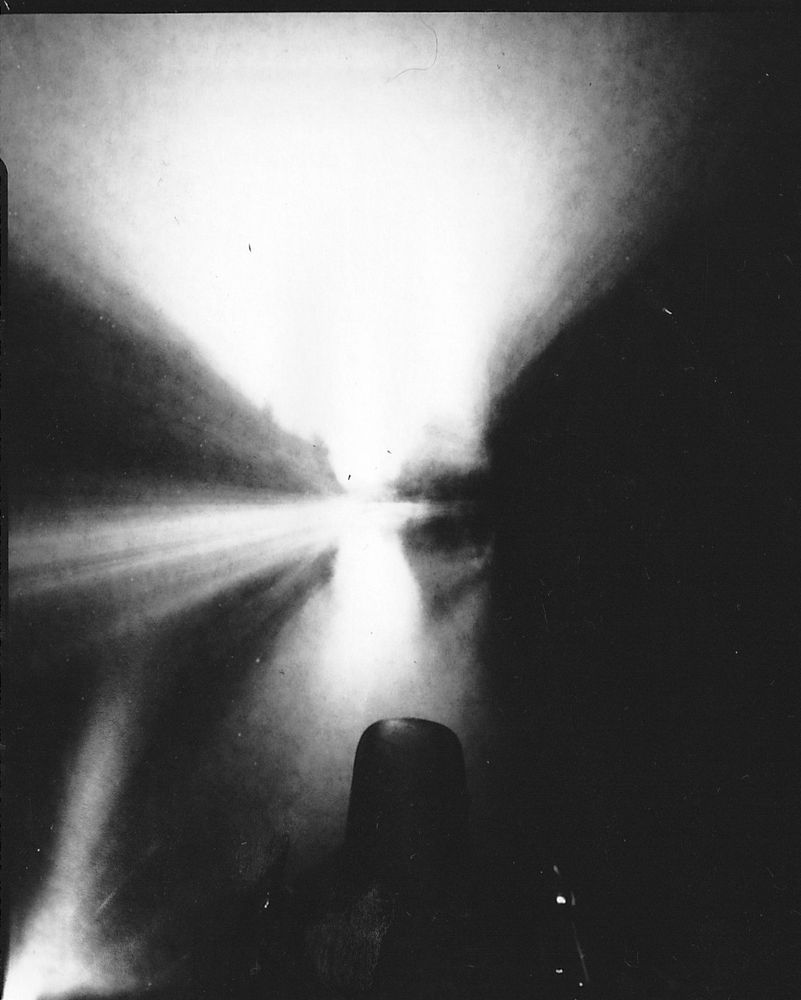 Black and white Pinhole photograph showing crisp in focus bow of canal boat against a smeary background 