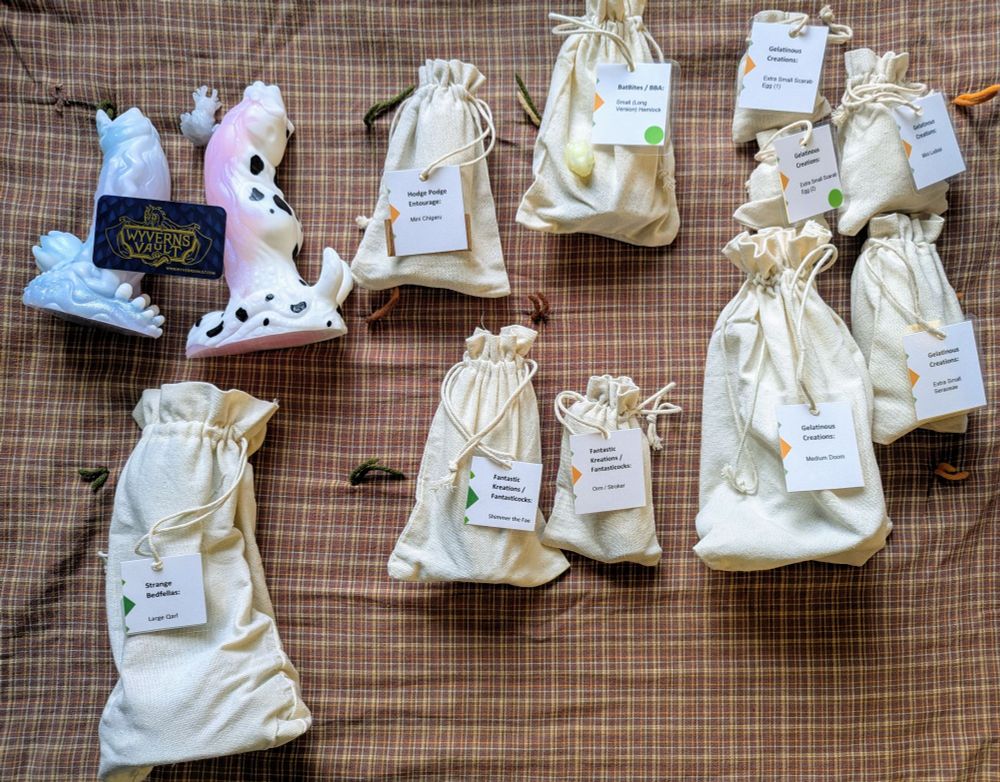 Collection of silicone adult toys and minis, mostly in bags with tags featuring their companies and model names.