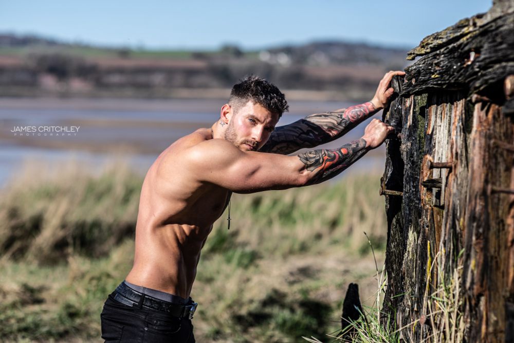 Sexy male model Shane Crommer shirtless outside.