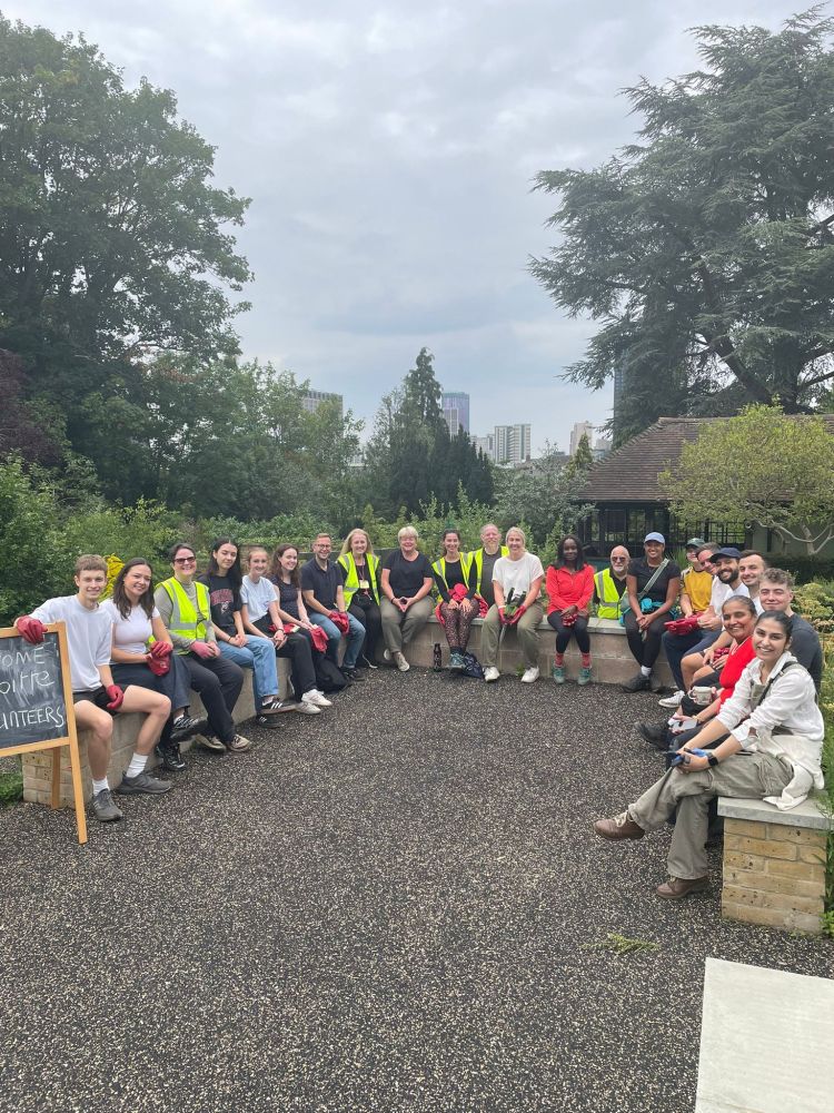 A large group of volunteers sat in the walled garden 