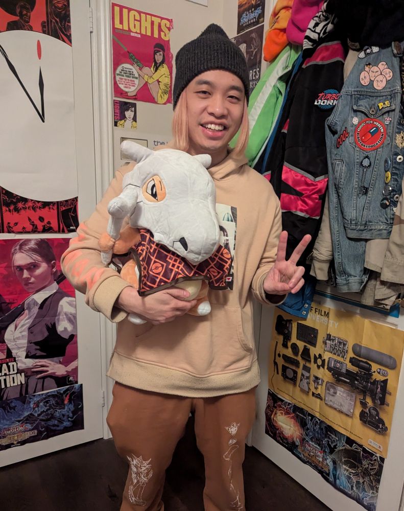 Boy holds a Cubone plushies.