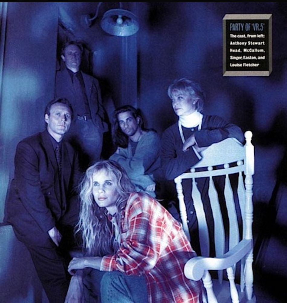 Cast of the 90s show VR.5: Anthony Stewart Head, David McCallum, Lori Singer, Michael Easton, and Louise Fletcher, mostly standing in a gloomy setting, while Lori Singer sits on a white rocking chair.