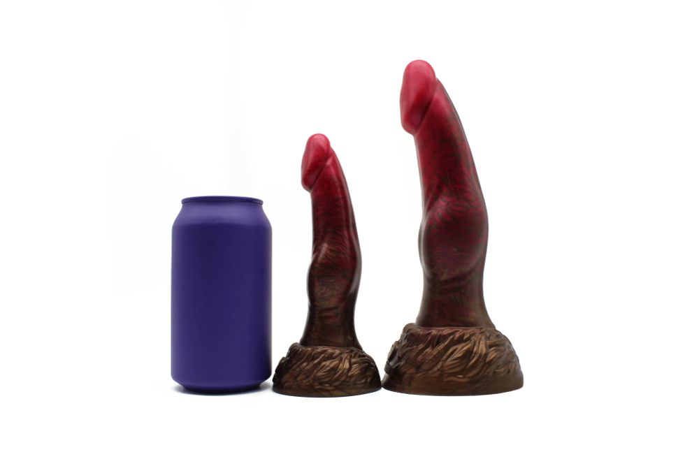 Two werewolf dildos standing upright beside a soda pop can for scale. They're two sizes of the same toy. The head is phallic and tapered, with a subtly curved shaft and a low-profile knot. The base is detailed with fur shaping.