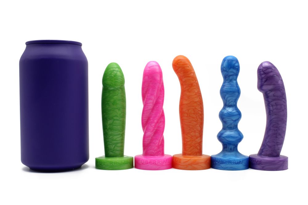 A soda pop can pictured beside a line of 5 petite dildos with flared bases. Each dildo is a unique shape, including a gentle spiral, a few curves, a beaded shape, etc.