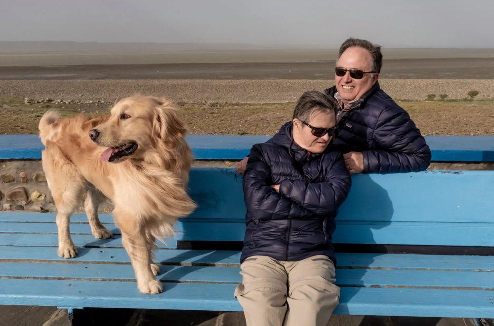Mr. Tomasín with his brother, Juan Mario Tomasín, and a neighborhood dog on the banks of the Rio Gallegos River. - NYTimes