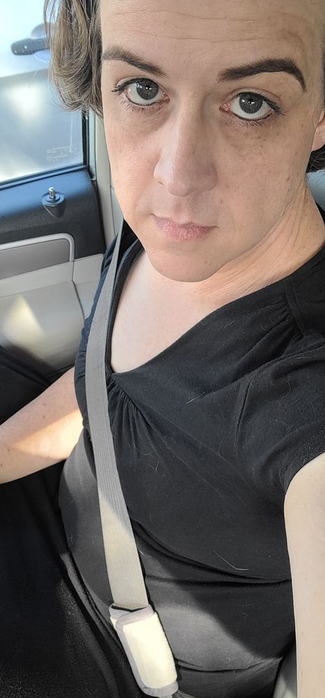 Woman dressed in an all black short sleeve shirt and skirt is giving an expression of sadness while waiting for labs