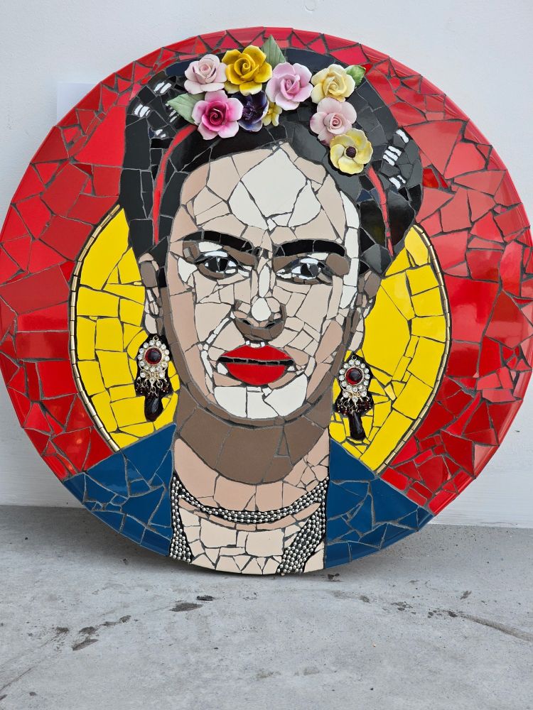 Frida Kahlo mosaic portrait artwork on a red and yellow background with porcelain flowered headband and red and diamanté earrings and a bead chain necklace