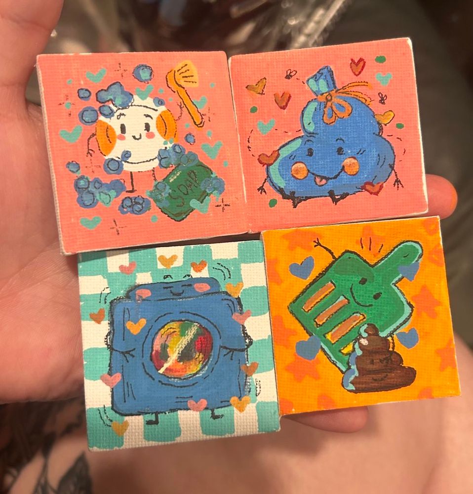 Four tiny canvases I painted with posca markers of chores to do around our home. From top over and down: Dishes, Trash bag, dryer, and cat litter poop scoop- all held in one of my hands! 
