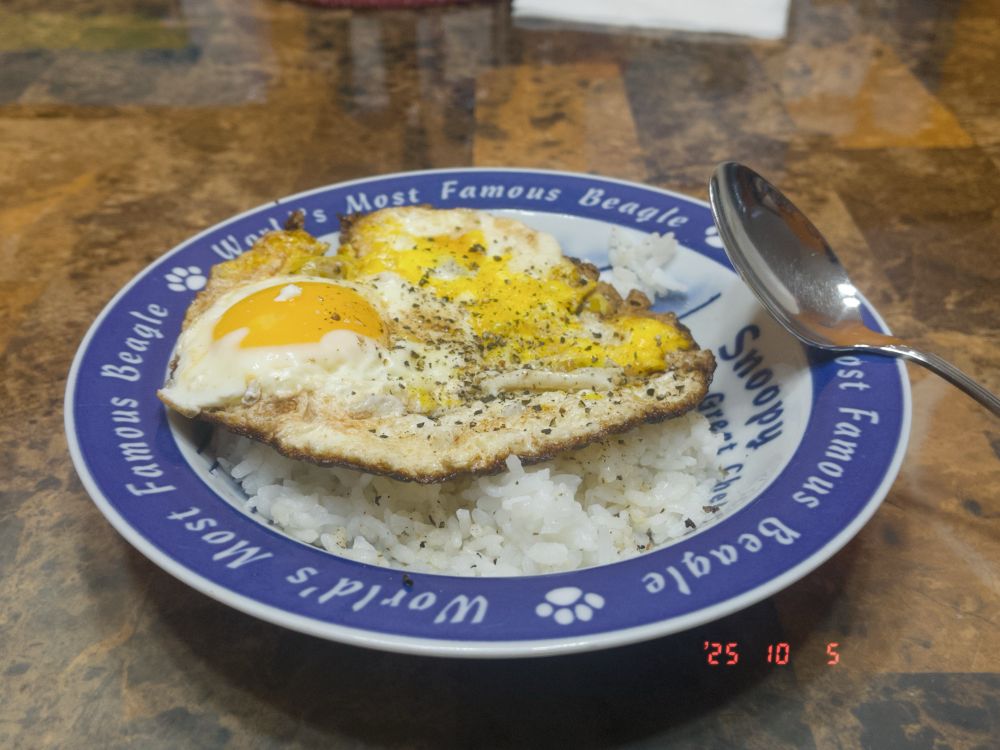 Fried egg over rice. One yolk broke, of the two of them, so one half of the egg is typical with a round yolk, and the other is more scrambled-ish. 