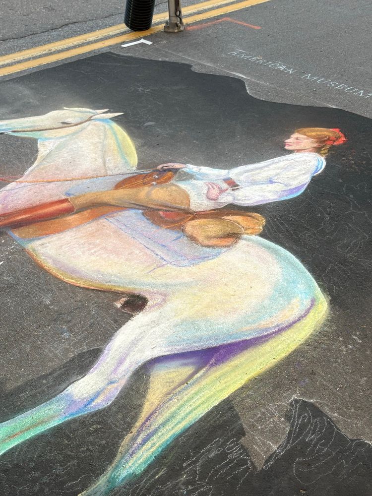 Chalk art of a woman riding a white horse