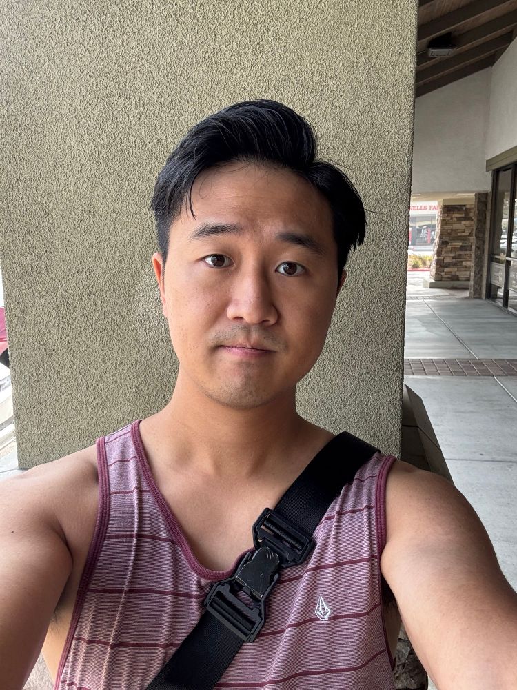 Selfie of Asian male with freshly cut hair in a side part and styled with wax.