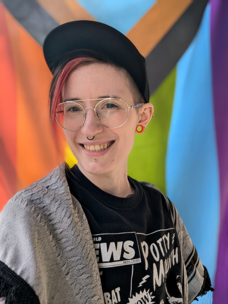 A selfie of me against a pride flag. 