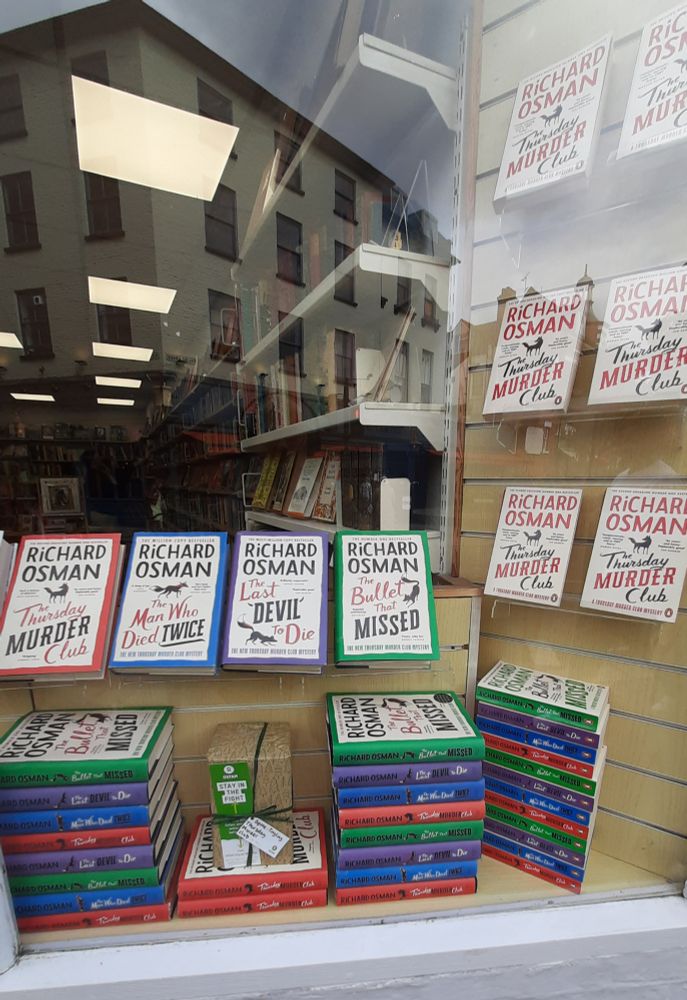 Oxfam shop window full of Thursday Murder Club books. 